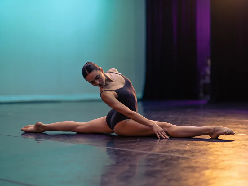 Стретчинг: девушка тянется в шпагат на занятии по растяжке